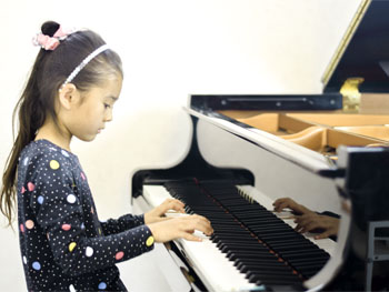 女の子がピアノを弾いてる